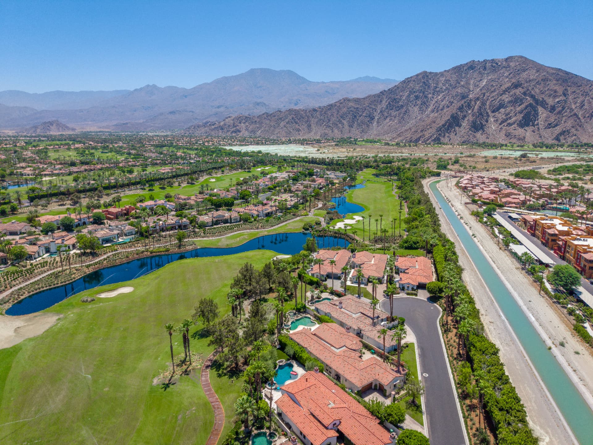 Aerial view of La Quinta golf course, lake, and mountains surrounding the residence